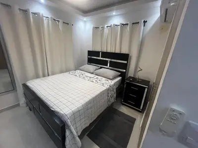 a small bed in a room with white curtains at Luxurious and cozy apartment in San Luis