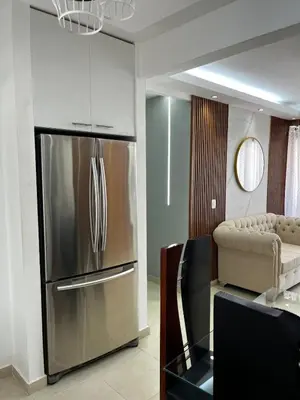 a kitchen with a stainless steel refrigerator and a couch at Luxurious and cozy apartment in San Luis