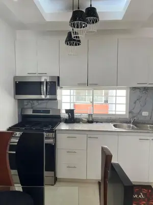 a kitchen with white cabinets and a black stove top oven at Luxurious and cozy apartment in San Luis