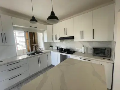 a white kitchen with white cabinets and a microwave at Apartmento, siéntete en casa in Monte Adentro
