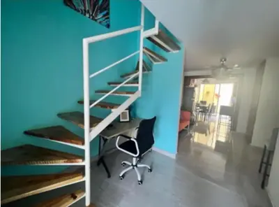 a staircase in a room with a desk and a blue wall at Casa colinas del viento in Jacagua