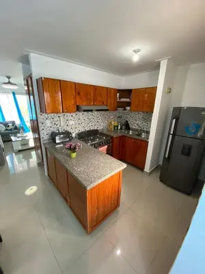 a kitchen with wooden cabinets and a counter top at Beautiful apartment near STGO airport in Santiago de los Caballeros