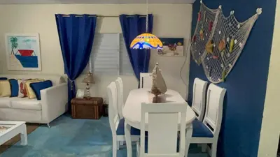 a living room with a white table and chairs at Villa Del Risco - House on the Beach in Boca Chica