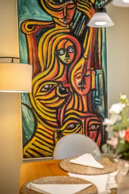 a painting of a woman on a wall with a table at Luxurious Apartment with pool near airport in Santiago de los Caballeros