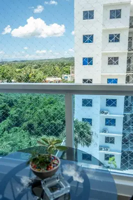 a view of a building from a window with a plant at Luxurious Apartment with pool near airport in Santiago de los Caballeros