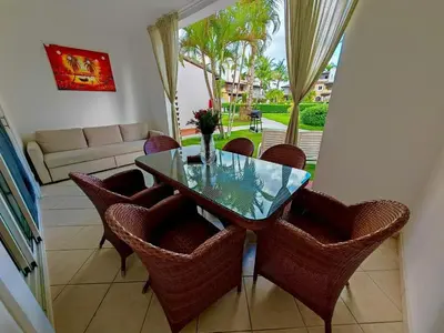 a dining room with a glass table and wicker chairs at Apartman Tamarindo in La Laguna