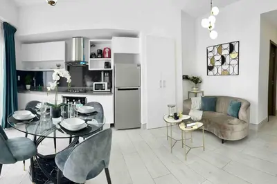 a kitchen and living room with a table and a couch at Comfy 1BR Apt, Full AC, Pool. in Santo Domingo