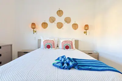 a bedroom with a white bed with pink and blue sheets at Comfy 3BD Condo in Cocotal in Punta Cana