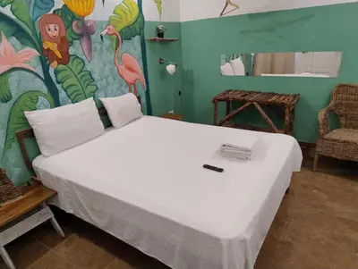 a bedroom with a large bed with a painting on the wall at Brisa de Alma Guesthouse in Bayahibe