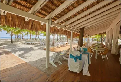 a pavilion with chairs and tables on a beach at Escape Oasis in Playa Dorada Pool & Beach in Puerto Plata
