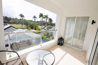 a balcony with chairs and a view of a yard at Modern 2BR Caribbean Apt -Pool & Beach Access in Puerto Plata