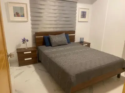 a bedroom with a large bed and two night stands at Apartamento tranquilo, céntrico y confortable in Santo Domingo