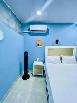 a blue room with a bed and a night stand at Beach Days & City Nights! Centrally Near Everything in Santo Domingo