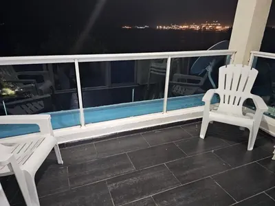 two chairs sitting on a balcony at night at Dreamvillage in Boca Chica