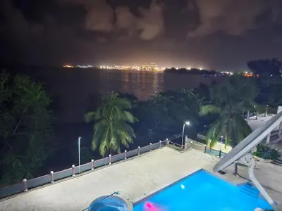 a view of the water at night with a swimming pool at Dreamvillage in Boca Chica