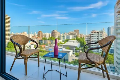 two chairs and a table with a vase on a window at Upscale City Center Condo in Santo Domingo