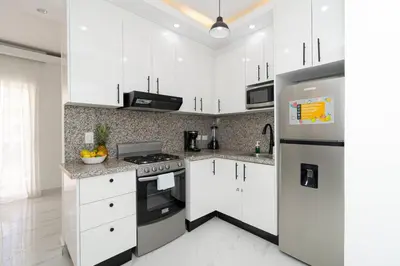 a white kitchen with a stove and a refrigerator at Cozy 1BR 1BA Bayahibe Getaway with Pool - Maravilla in San Rafael del Yuma