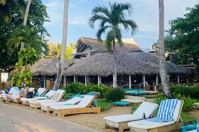 a group of lounge chairs in front of a resort at Bonita Beach Villa in Las Terrenas