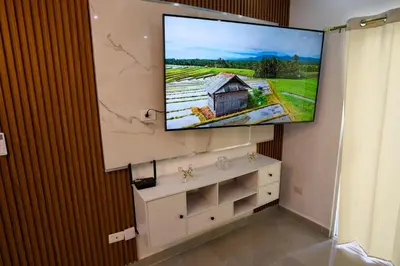 a flat screen tv hanging on a wall in a room at Amazing 2BR apartment near the airport in Los Frailes