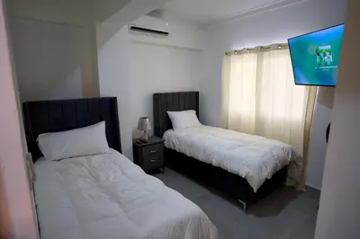 a bedroom with two beds and a tv in it at Amazing 2BR apartment near the airport in Los Frailes