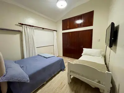 a bedroom with two beds and a tv in it at Villa in Metro Country Club, Juan Dolio in Juan Dolio