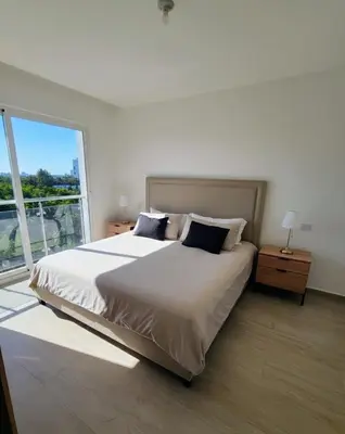 a bedroom with a large bed with a large window at Apartamento de Lujo Punta Cana Hard Rock in Punta Cana