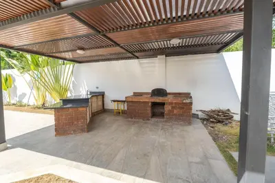 an outdoor patio with a brick fireplace and a wooden roof at Villa Monaco RD in Concepción de La Vega