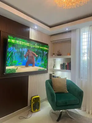 a living room with a tv and a green couch at Casa Bonita con Jacuzzi in Los Mameyes