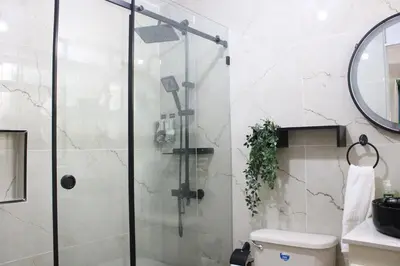 a bathroom with a shower with a toilet and a mirror at Casa Bonita con Jacuzzi in Los Mameyes