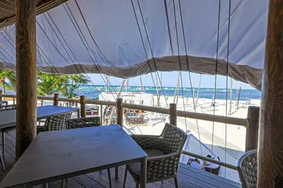 a view of the beach from a restaurant with tables and chairs at Elegant Cocotal 2BD Condo in Punta Cana