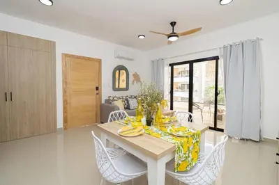 a dining room with a table and white chairs at Sylish 2 Bed Retreat in Sunshine Bayahibe in San Rafael del Yuma