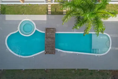 an overhead view of a swimming pool with a palm tree at Sylish 2 Bed Retreat in Sunshine Bayahibe in San Rafael del Yuma