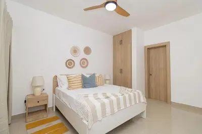 a white bedroom with a bed and a ceiling fan at Sylish 2 Bed Retreat in Sunshine Bayahibe in San Rafael del Yuma
