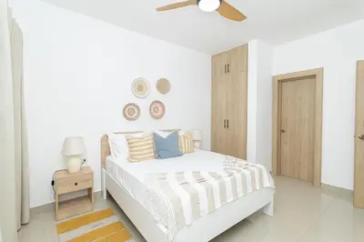 a white bedroom with a bed and a ceiling fan at Sylish 2 Bed Retreat in Sunshine Bayahibe in San Rafael del Yuma