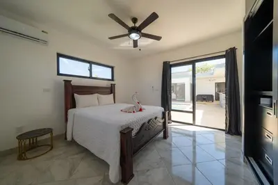 a bedroom with a bed and a ceiling fan at Brand New Modern Caribbean Retreat 3BR in Sosúa