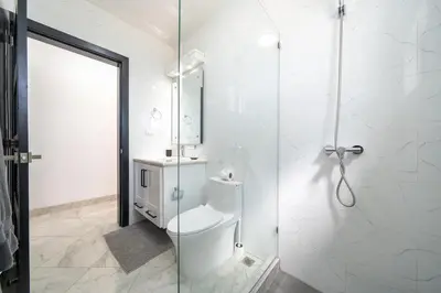 a bathroom with a toilet and a glass shower at Brand New Modern Caribbean Retreat 3BR in Sosúa