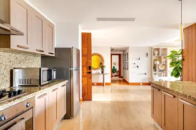 a kitchen with a stainless steel refrigerator and wooden cabinets at Casa Cielo 3 BR Penthouse with Views in La Romana