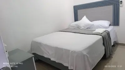 a bedroom with a bed with white sheets and pillows at Remanso de Paz in Pedernales