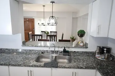 a kitchen counter with a sink and a dining room at Emerald Vue - Private river entrance in Jarabacoa