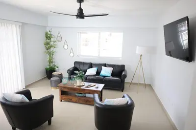 a living room with a couch and chairs and a table at Emerald Vue - Private river entrance in Jarabacoa