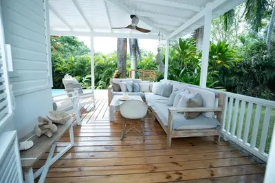 a porch with a couch and chairs on it at Modern villa with private pool 1 km from the beach samana in El Limón