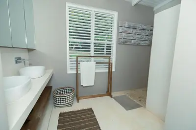 a bathroom with a sink and a toilet and a window at Modern villa with private pool 1 km from the beach samana in El Limón