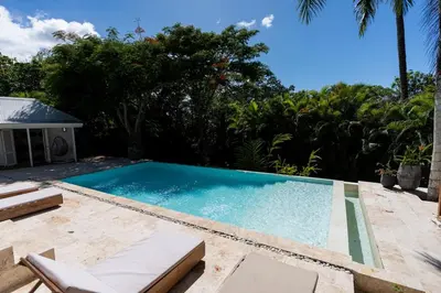a swimming pool with two lounge chairs on a patio at Modern villa with private pool 1 km from the beach samana in El Limón