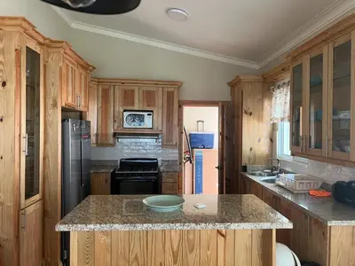 a kitchen with wooden cabinets and a bowl on a counter at Villa Enma RD in Nizao
