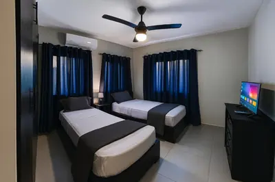 a hotel room with two beds and a flat screen tv at Penthouse with Large Rooftop Terrace & Parking in Sosúa