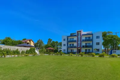 a building with a large lawn in front of it at Penthouse with Large Rooftop Terrace & Parking in Sosúa