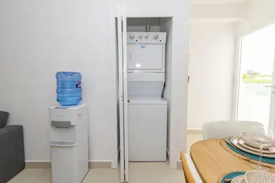 a kitchen with a refrigerator and a table at Modern 2BR Condo with Pool 10min walk to Beach - Caribbean Rose in San Rafael del Yuma