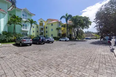a parking lot with cars parked in front of buildings at Ocean front, direct access to the beach in Cabarete