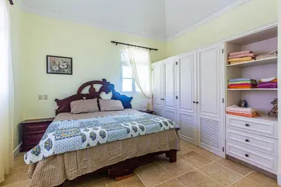 a bedroom with a bed in a room with shelves at Ocean front, direct access to the beach in Cabarete