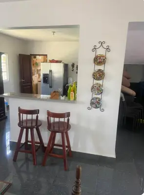 a kitchen with two stools and a counter with a refrigerator at Villa Rancho losindios